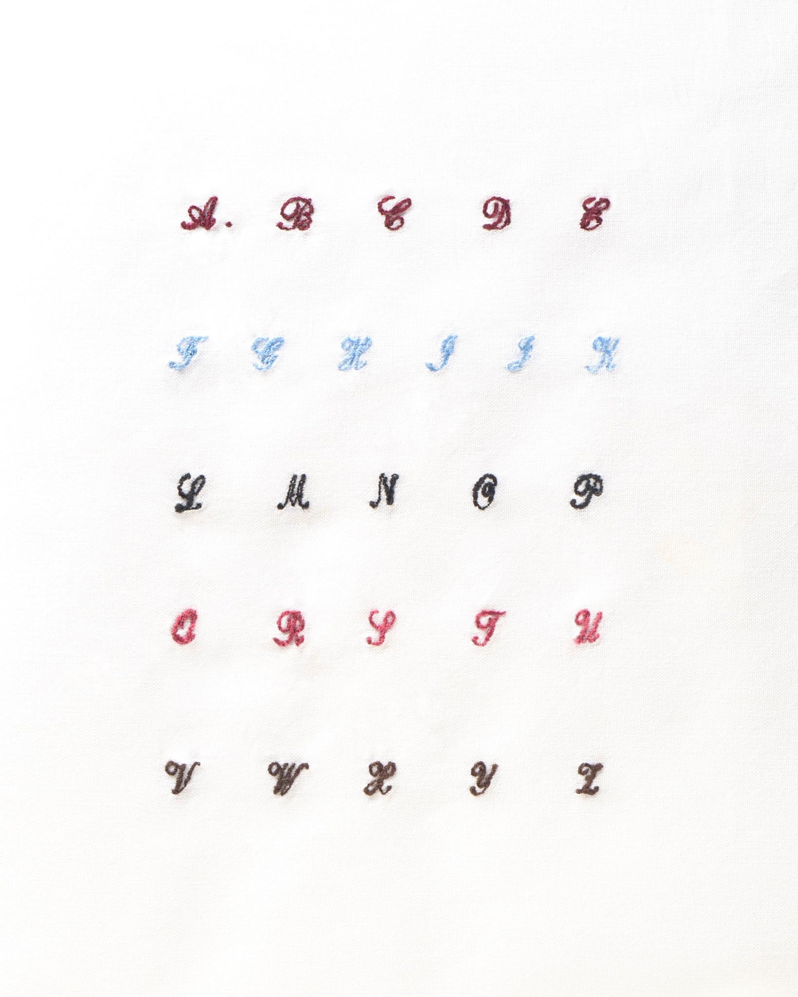 iniziali ricamate in corsivo