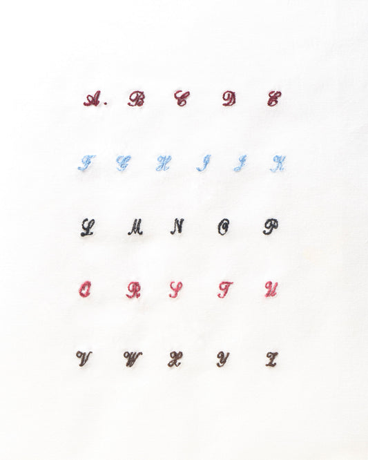 iniziali ricamate in corsivo