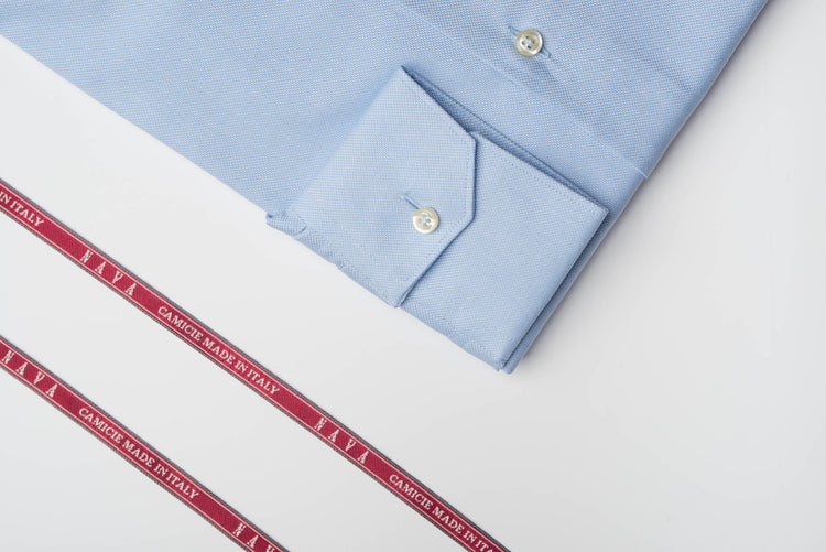 dettaglio di camicia azzurra con rocchetto filo e nastri